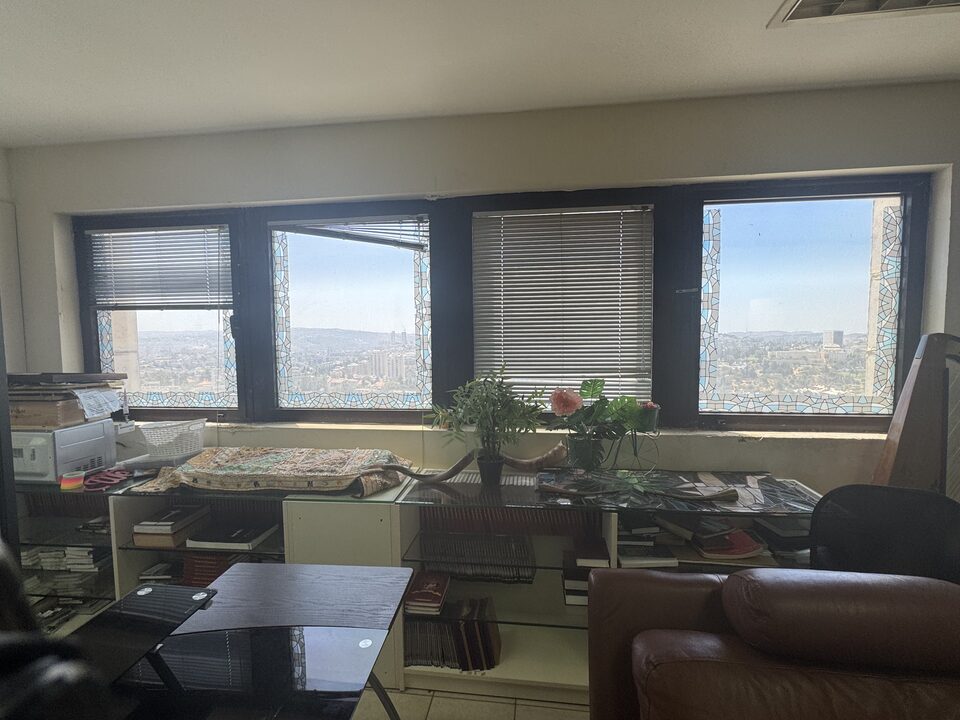 The greeting room, lined with books and looking out across the Jerusalem hills